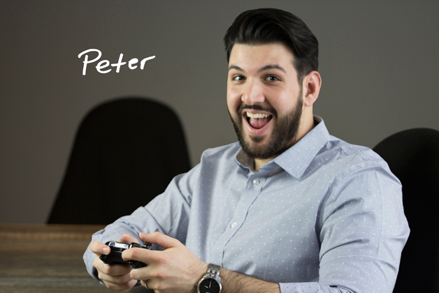 Headshot of Peter Sgouros holding gaming controller with his signature